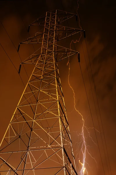 Pylon elektřiny s bleskem v pozadí. — Stock fotografie