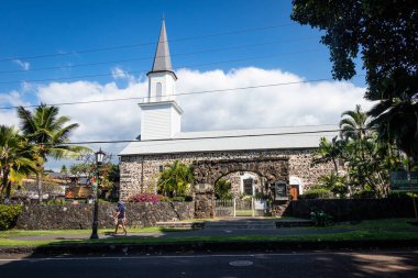 KAILUA-KONA, HI, ABD - 2 Ocak 2021: Mokuaikaua Kilisesi 'nin önünden geçen bir çiftin fotoğrafı. 1820 'de misyonerler tarafından kurulan Hawaii' nin en eski Hristiyan kilisesi..