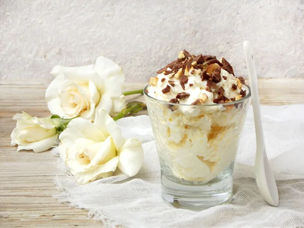 Manteiga caseira ou sorvete de limão polvilhado com nozes e chocolate em um copo em um fundo de madeira leve — Fotografia de Stock
