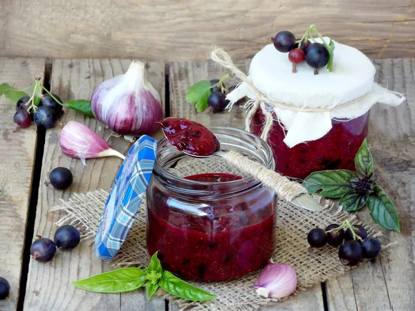 De zoute saus aan het vlees van zwarte bessen met basilicum en knoflook in een pot — Stockfoto