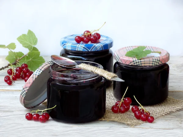 Drie potje jam van de rode bessen op een houten achtergrond — Stockfoto