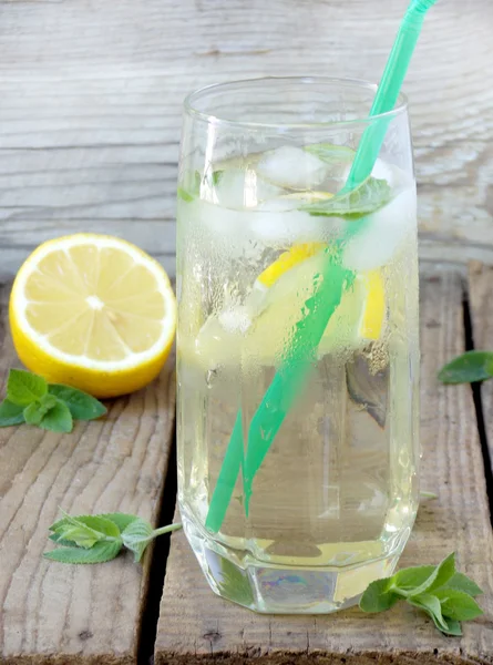 Glas kalte Limonade mit Eis, Zitrone, Minzblättern und Stroh. — Stockfoto