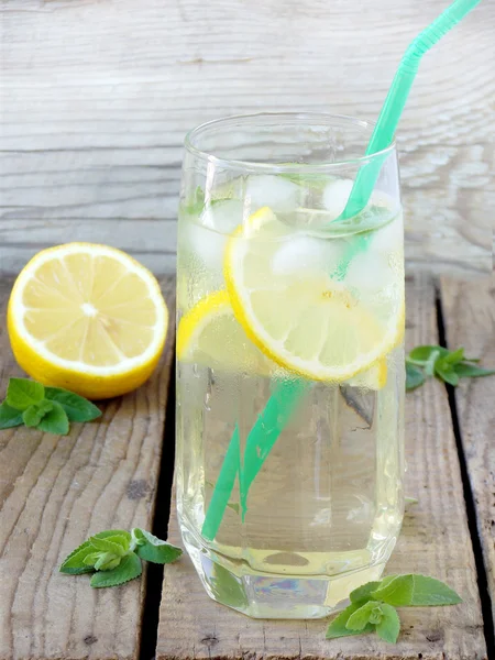 Glas kalte Limonade mit Eis, Zitrone, Minzblättern und Stroh. — Stockfoto