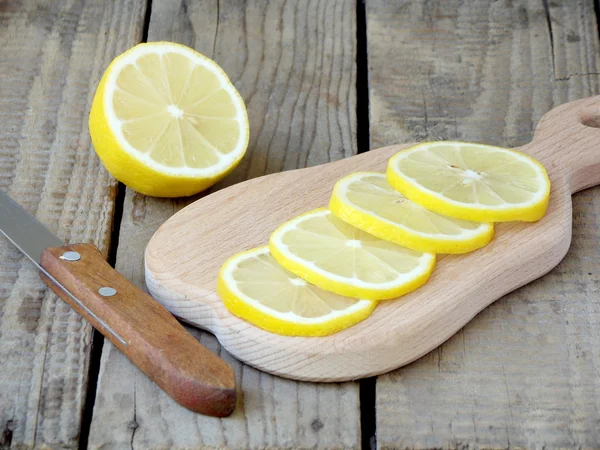 Tranches de citron hachées sur une planche de bois — Photo