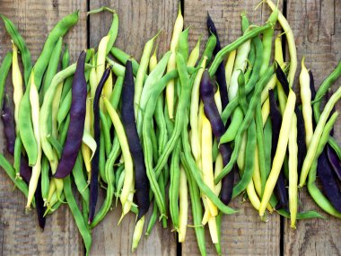 taze yeşil, sarı ve mor yeşil fasulye, ahşap bir arka plan üzerinde kuşkonmaz