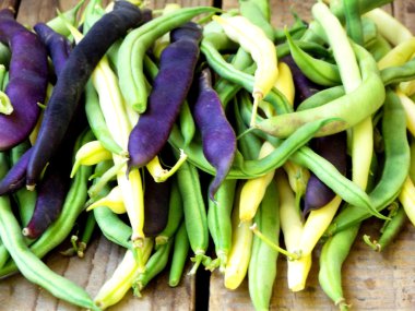 taze yeşil, sarı ve mor yeşil fasulye, ahşap bir arka plan üzerinde kuşkonmaz