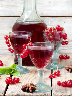 ahşap bir arka plan üzerinde ev yapımı kırmızı kuş üzümlü likör