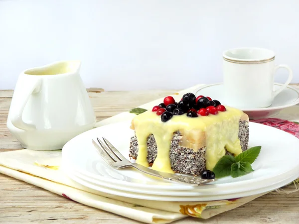 Cottage cheese and poppy cheesecake with blueberries, cranberries poured on yellow vanilla sauce. cake on light background. selective focus — Stock Photo, Image