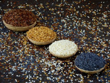 keten, susam ve haşhaş tohumları karanlık bir arka plan üzerinde. seçici odak