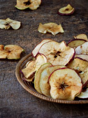 Ahşap bir arka plan üzerinde kase kurutulmuş elma. seçici odaklama