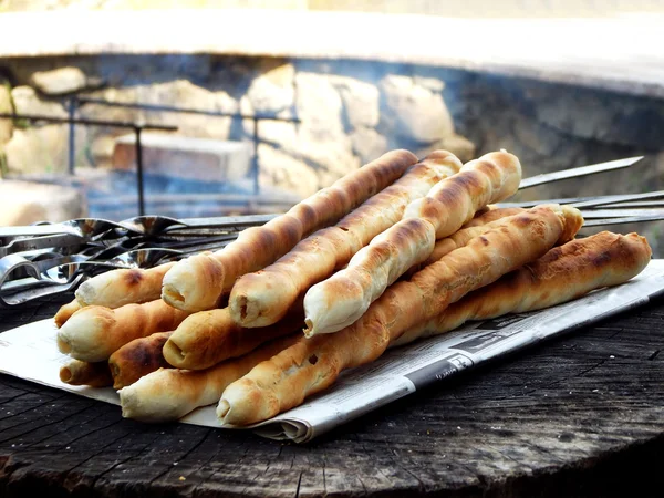 Paus de pão de massa de farinha cozinhada em uma fogueira. Paus de pão italianos. foco seletivo — Fotografia de Stock