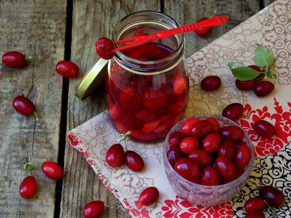 Blik van kornoelje (cornelian cherry berry) op houten achtergrond. — Stockfoto