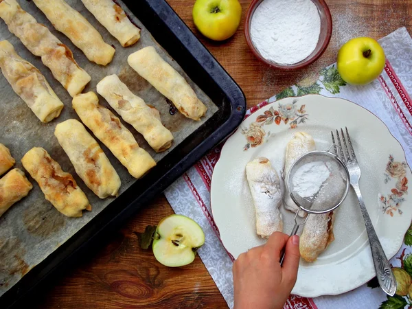 Portioned small strudel with apples sprinkled with cinnamon and powdered sugar — Stock Photo, Image