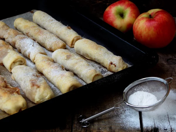 Portioned small strudel with apples sprinkled with cinnamon and powdered sugar — Stock Photo, Image