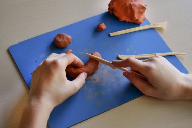 Kil şekillendiren çocuklar, ahşap aletler kullanarak, el yapımı, el yapımı, iyi motor beceri kavramını geliştirmek ve şekillendirmek için 4. adımlarını atıyorlardı.