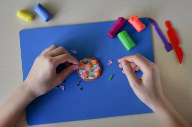 Plasticine Donut 'ı dekore eden çocuklar yaratıcı öğrenme aktivitesi el yapımı yemek sanatları iyi motor beceri geliştirme eğitim kavramına sahipler.