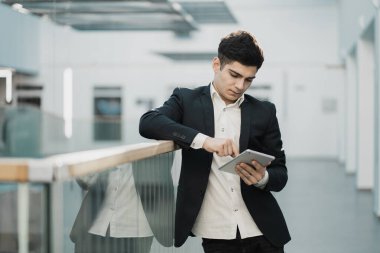 Elinde bir cihaz tutuyor, tra sitesinin istatistiklerine bakıyor.