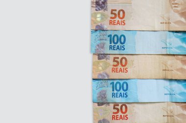Brezilya Real banknotları beyaz arka planda izole edilmiş, kopyalama alanı var. Brezilya parası işte. Dikey fotoğraf.