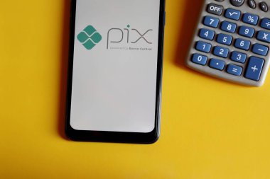 Bahia, Brezilya - 9 Ekim 2020. Akıllı telefon ekranında pix logosu ve sarı arka planda hesap makinesi. Pix, Brezilya Merkez Bankası 
