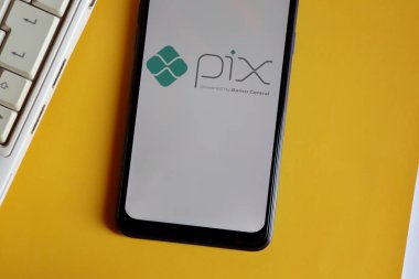Bahia, Brezilya - 9 Ekim 2020. Akıllı telefon ekranında pix logosu ve sarı arka planda laptop. Pix, Brezilya Merkez Bankası 