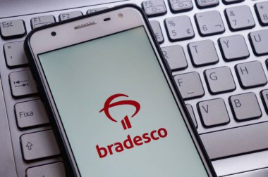 Bahia, Brezilya. 30 Nisan 2020. Akıllı telefon ekranındaki beyin uygulaması dizüstü bilgisayarın klavyesinin üstünde. Bradesco Bankası. Brezilya bankası. İnternet bankacılığı kavramı.