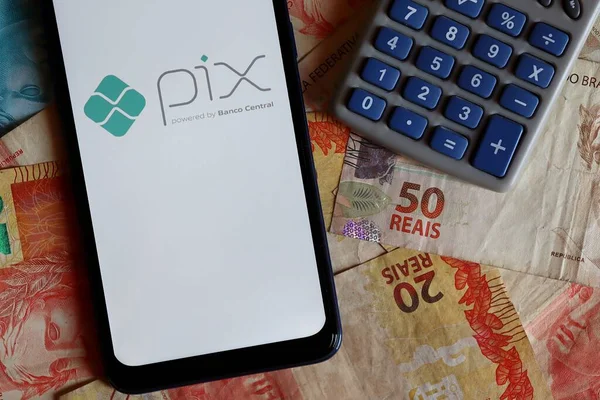 2020年10月9日 智能手机屏幕上的Pix标志和巴西真钞票上方的计算器 Pix是巴西中央银行提供的新的即期支付系统 — 图库照片