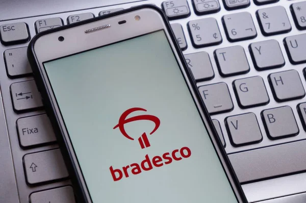 Bahia, Brezilya. 30 Nisan 2020. Akıllı telefon ekranındaki beyin uygulaması dizüstü bilgisayarın klavyesinin üstünde. Bradesco Bankası. Brezilya bankası. İnternet bankacılığı kavramı.