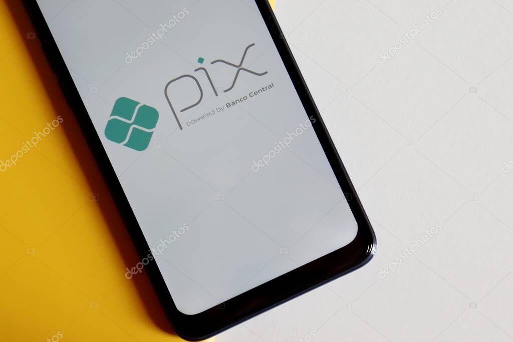 Bahia, Brazil - October 6, 2020. Pix logo on smartphone screen on white and yellow background. Pix is the new instant payment system from Central Bank of Brazil (Banco Central do Brasil).