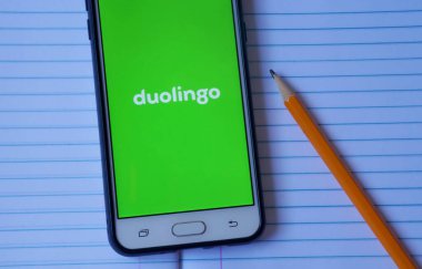Bahia, Brezilya - 14 Mayıs 2020. Duolingo uygulaması akıllı telefon ekranında defterin üstünde. Yeni dil kavramı öğreniliyor.