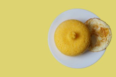 Sarı arka planda izole edilmiş yumurtalı kuskus manzarası. Brezilya kuskusu (Cuscuz brasileiro).