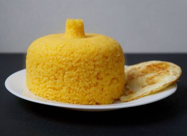 Brezilya kuskusu (cuscuz Brasileiro) ve sahanda yumurta. Kahvaltı konsepti. Geleneksel Brezilya yemeği mısır unundan hazırlandı.