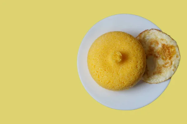 Sarı arka planda izole edilmiş yumurtalı kuskus manzarası. Brezilya kuskusu (Cuscuz brasileiro).