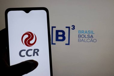 Bahia, Brezilya - 24 Şubat 2021: Arkaplanda B3 Ibovespa logosu olan akıllı telefon ekranında Grupo CCR logosu. CCR, Brezilyalı bir holding şirketi. Yatırım kavramı.