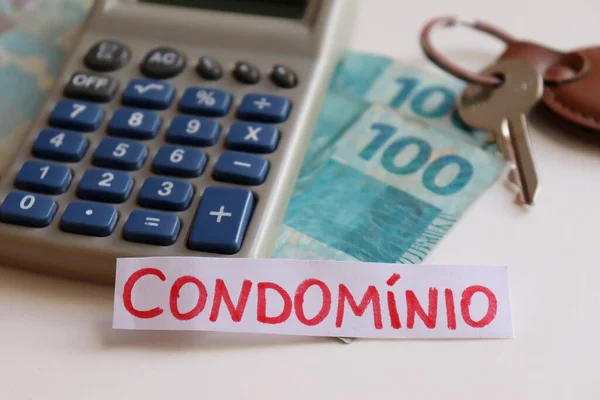 Çevirisi: Apartman ücretleri. £124; Brezilya parası, hesap makinesi, ev anahtarları ve üzerinde Condominio yazan not. Brezilya 'da kondominyum ücretleri kavramı.