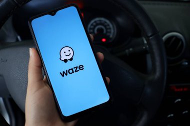 Bahia, Brezilya - 30 Nisan 2021: Waze uygulamalı akıllı telefonu ekranda, bir arabada tutan kişi. Waze logosu.