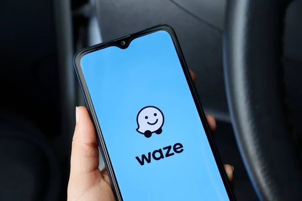 Bahia, Brezilya - 30 Nisan 2021: Waze uygulamalı akıllı telefonu ekranda, bir arabada tutan kişi. Waze logosu.