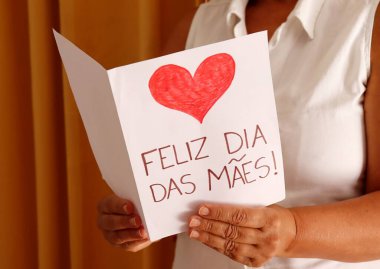 Annem Feliz Dia das Maes 'i tutuyor. Mutlu Anneler Günü, Portekizce. Hediye kartı.. 