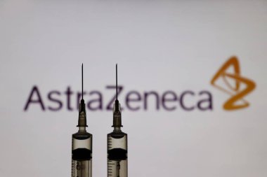 Bahia, Brezilya - 3 Mayıs 2021: Arkaplanda bir ekranda şırınga ve AstraZeneca logosu gösterildi. Covid-19 Oxford-Astrazeneca Aşısı.
