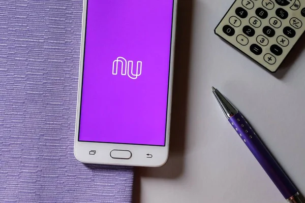 Bahia, Brezilya - 20 Eylül 2020. Akıllı telefon ekranındaki Nubank uygulaması mor arka planda, hesap makinesi ve kalemle. Nubank bir Brezilya Dijital Bankası..