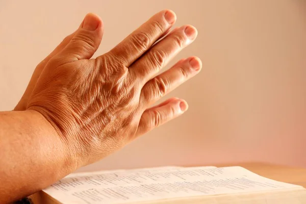 Elderly Woman hands on Bible. Praying Hands over the Holy Bible. Faith concept.