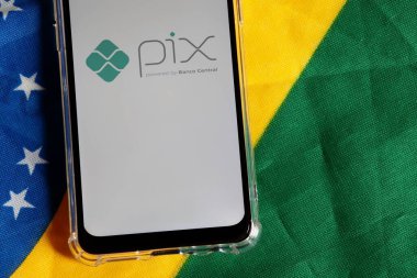 Bahia, Brezilya - 6 Ekim 2020. Brezilya bayraklarının tepesindeki akıllı telefon ekranında Pix Brazil logosu. Pix, Brezilya Merkez Bankası 