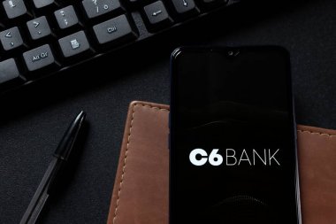 Bahia, Brezilya - 27 Ekim 2020: C6 Bank logosu akıllı telefon ekranında, ofis masasında. Brezilya Dijital Bankası 'ndan. C6 Banka uygulaması.