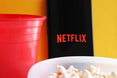 Bahia, Brezilya - 21 Ekim 2020. Arka planda bir kase patlamış mısır, kupa ve Netflix uygulaması var. Netflix logosu.