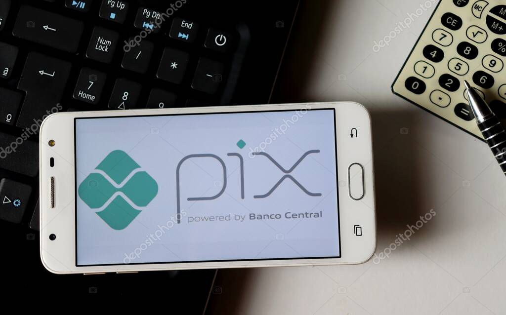 Bahia, Brazil - October 9, 2020. Pix logo on smartphone screen on office desk. Pix is the new instant payment system from Central Bank of Brazil (Banco Central do Brasil).