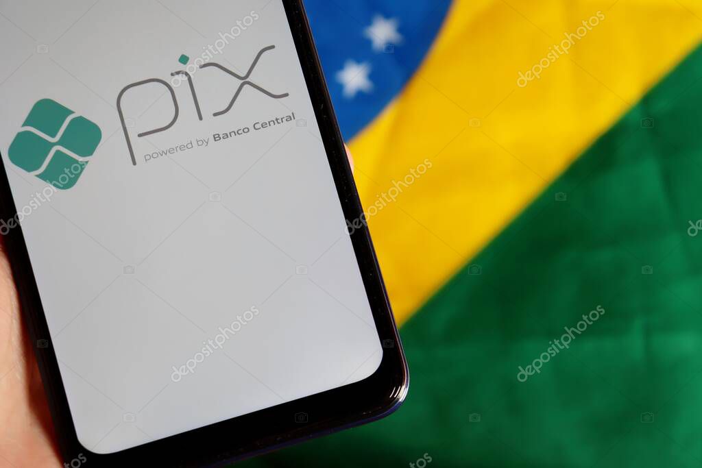 Bahia, Brazil - October 6, 2020: Pix Brazil logo on smartphone screen on top of Brazilian flag. Pix is the new instant payment system from Central Bank of Brazil (Banco Central do Brasil).