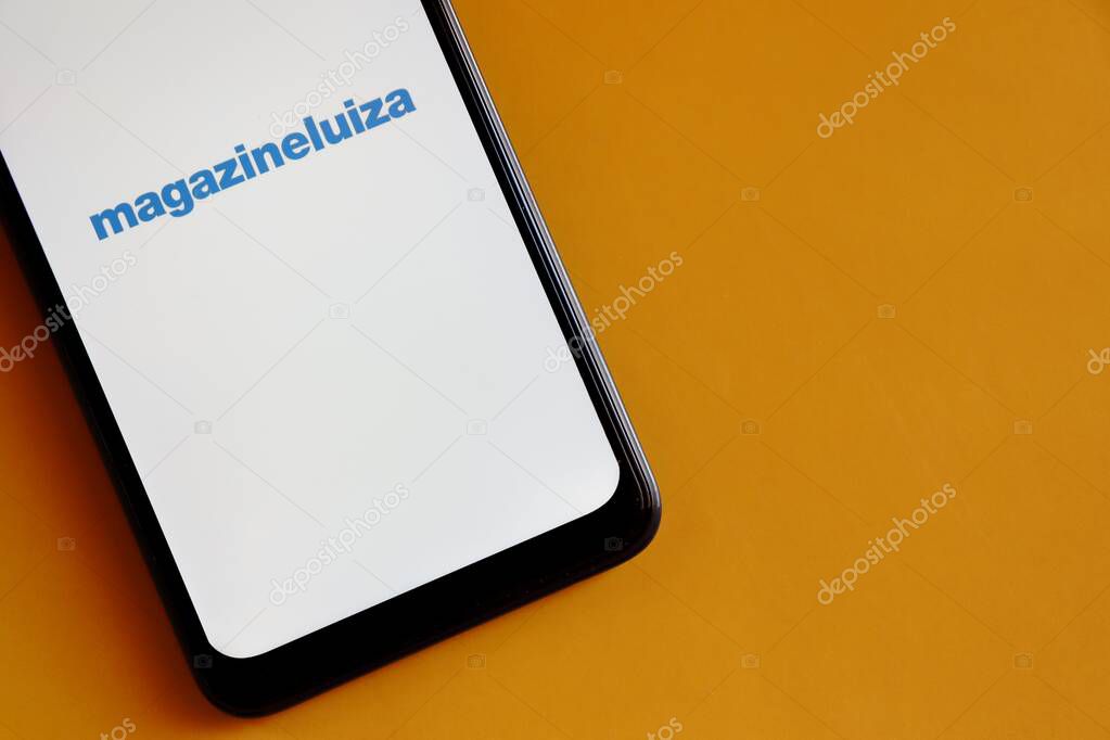 Bahia, Brazil - October 6, 2020: Magazine Luiza App on smartphone screen on yellow background. Magazine Luiza (or Magalu) is a Brazilian retail company.