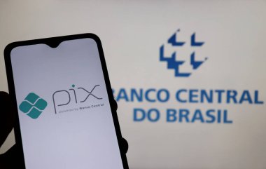 Bahia, Brezilya - 26 Mart 2021: Arka planda Banco Central do Brasil logosu sergilenen akıllı telefon ekranında Pix logosu. Pix bir Brezilya ani ödeme sistemidir..