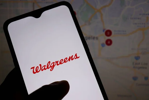 巴西巴伊亚州 2021年5月10日 以美国地图为背景的智能手机屏幕上的沃尔格林标志 图库图片