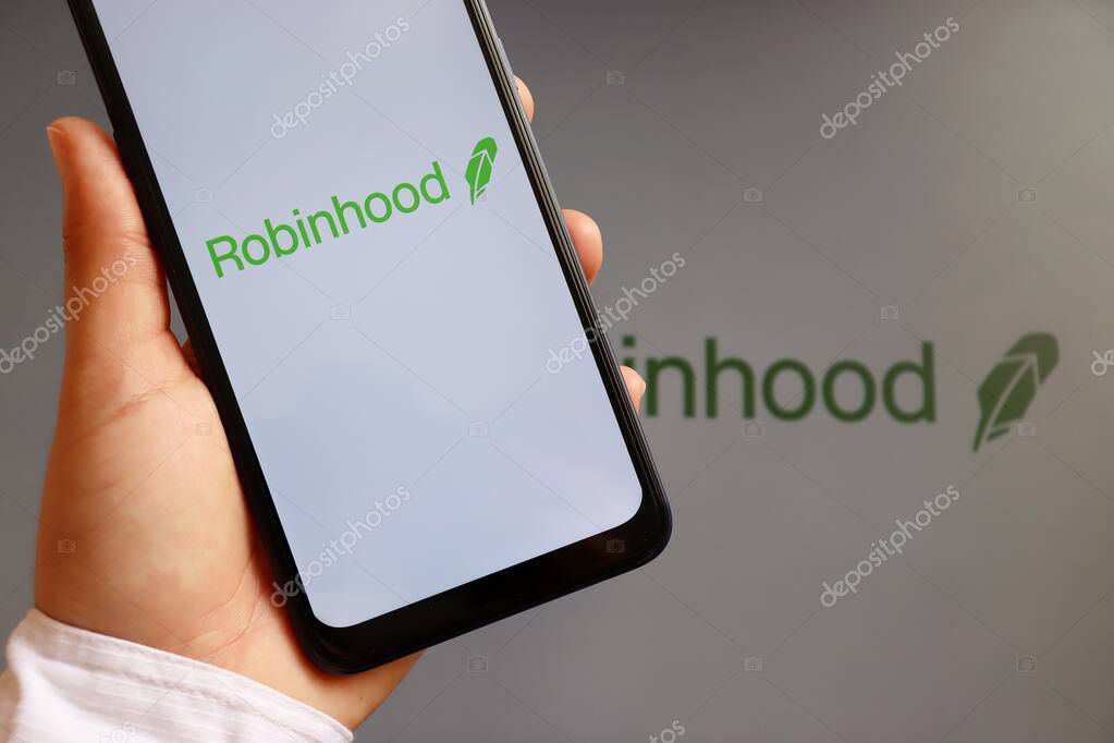 Bahia, Brazil - February 10, 2021. Woman holding smartphone with Robinhood Markets logo on screen. Financial services.