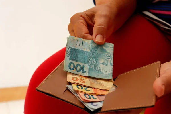 拿着钱包和巴西真钞票的女人巴西货币概念 图库照片